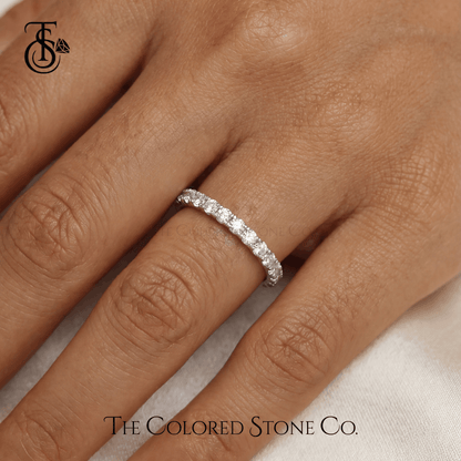 white gold Diamond wedding ring on a hand with 'The Colored Stone Co.' branding.