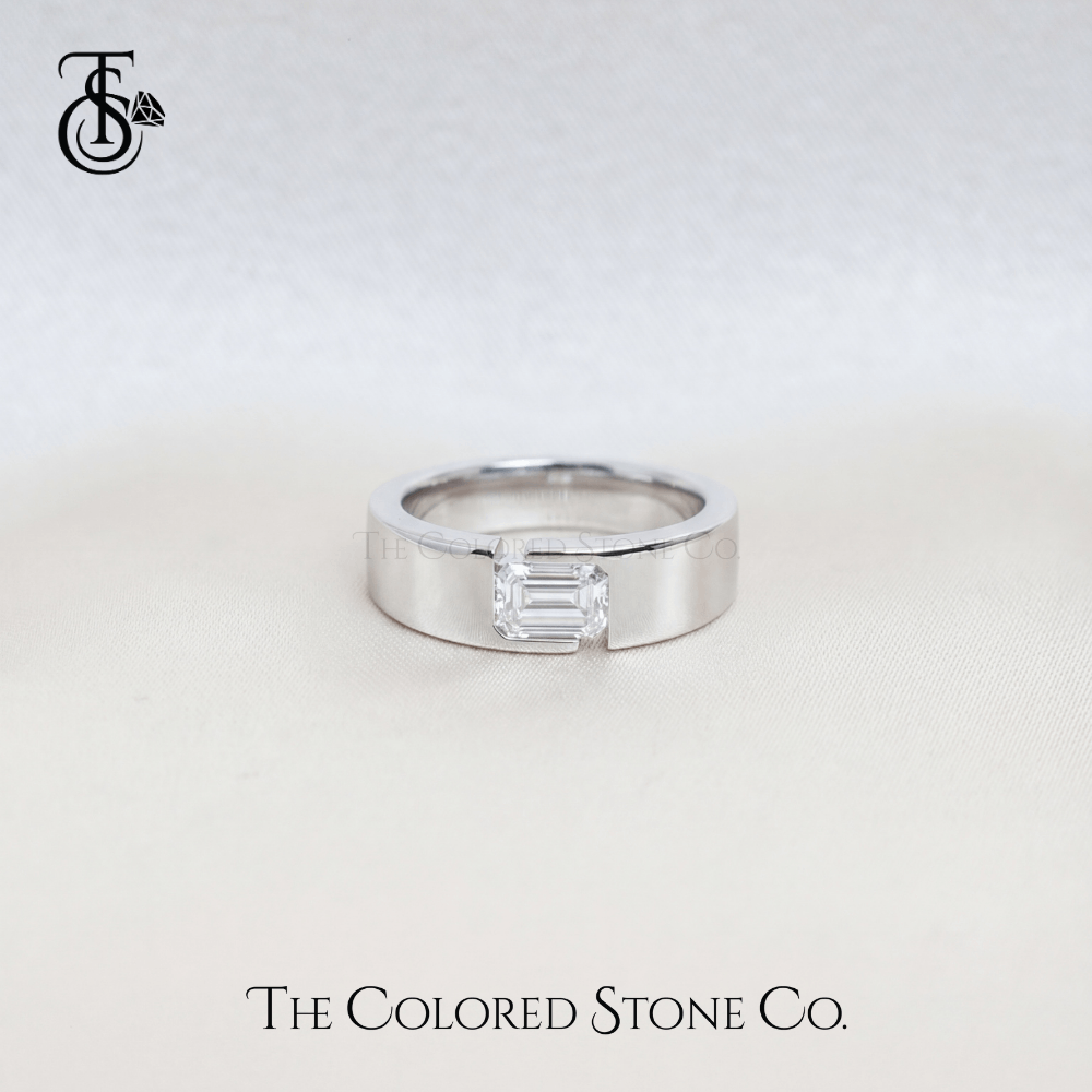 Silver men's wedding ring with a rectangular diamond on a light gray background, featuring 'The Colored Stone Co.' branding.