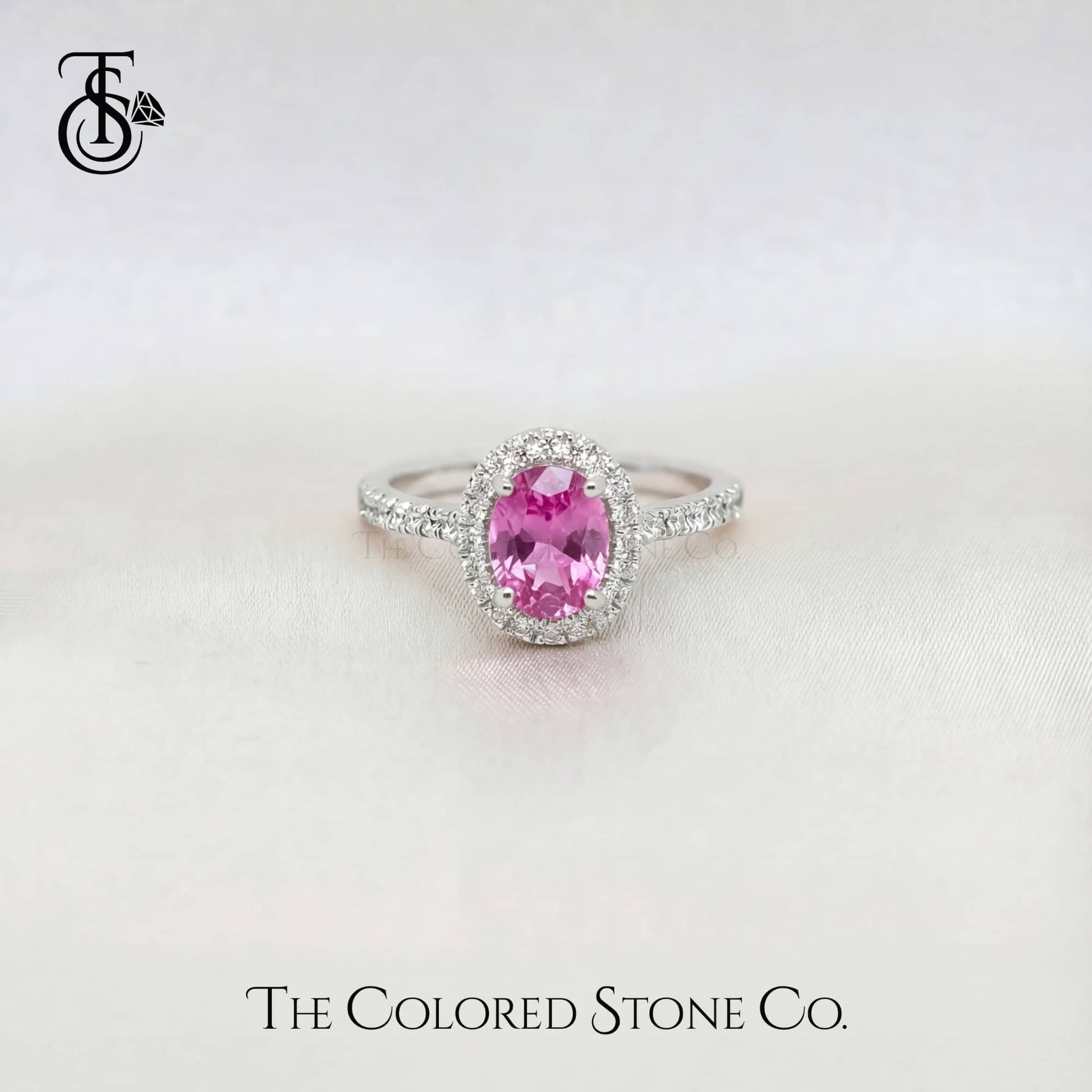 white gold engagement Ring with a pink sapphire gemstone on a white background, featuring 'The Colored Stone Co.' branding.