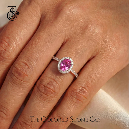 Pink gemstone ring on a hand with 'The Colored Stone Co.' branding.