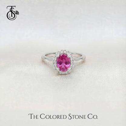white gold enagement ring with a pink sapphire gemstone on a white background, branded 'The Colored Stone Co'.