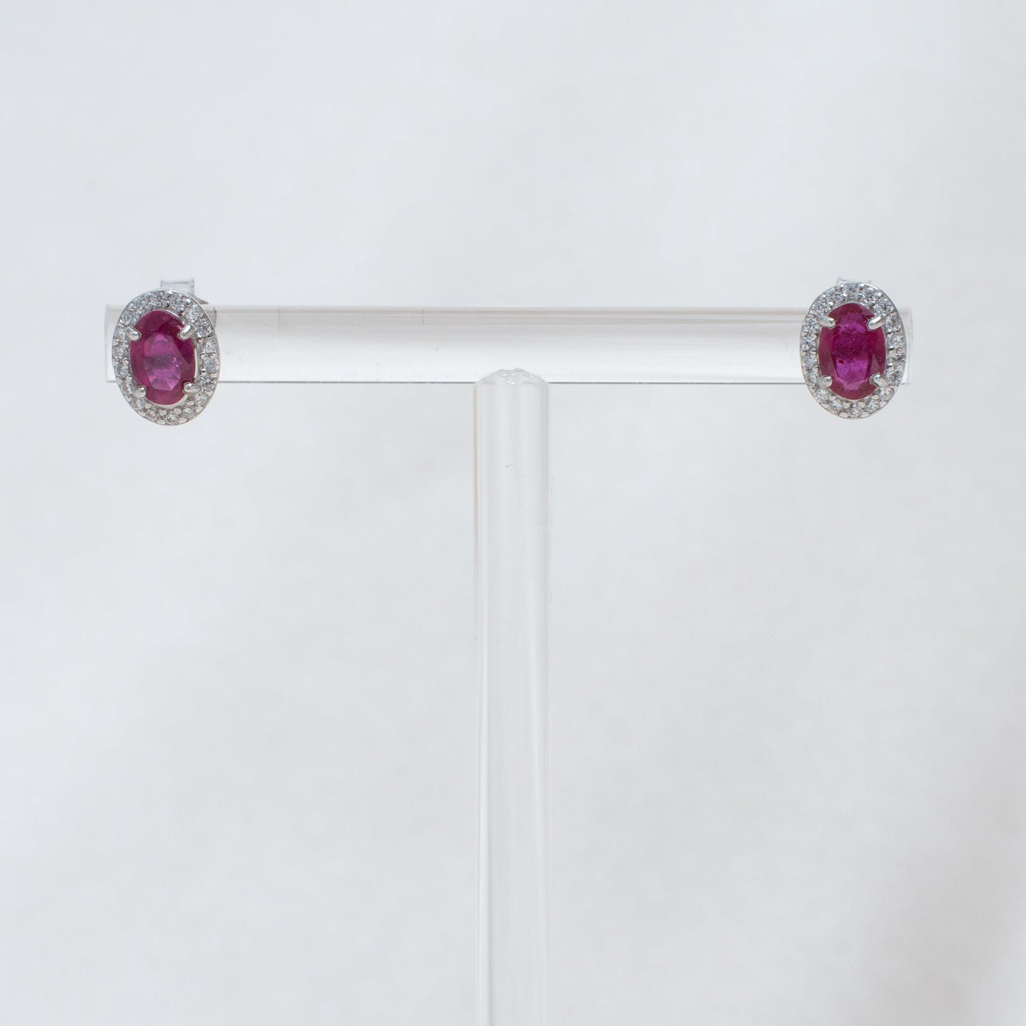 Pair of earrings with red gemstones on a white background