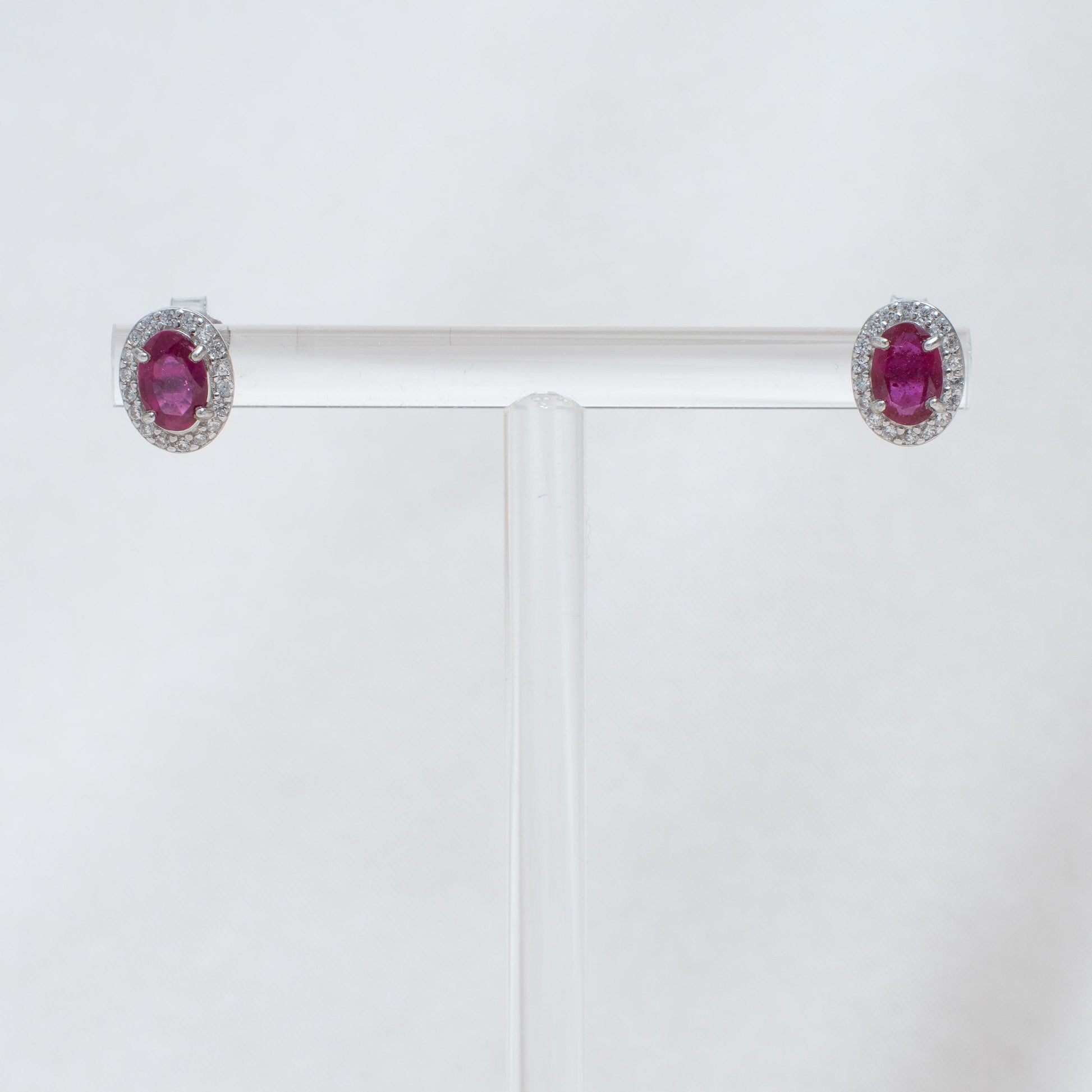 Pair of earrings with red gemstones on a white background