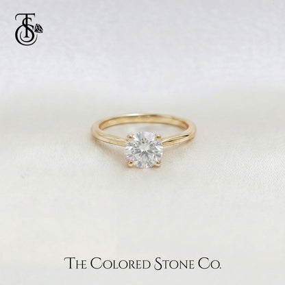 Yellow Gold engagement ring with a diamond on a light background, featuring 'The Colored Stone Co.' logo.