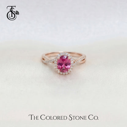 Rose gold engagement ring with a pink sapphire gemstone on a light background, featuring 'The Colored Stone Co.' branding.