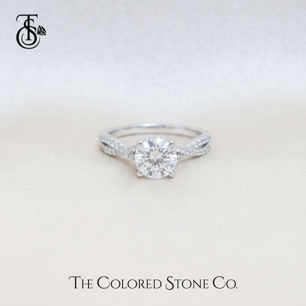 Diamond engagement ring on a light beige background with 'The Colored Stone Co.' branding.