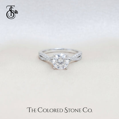 Diamond engagement ring on a light beige background with 'The Colored Stone Co.' branding.